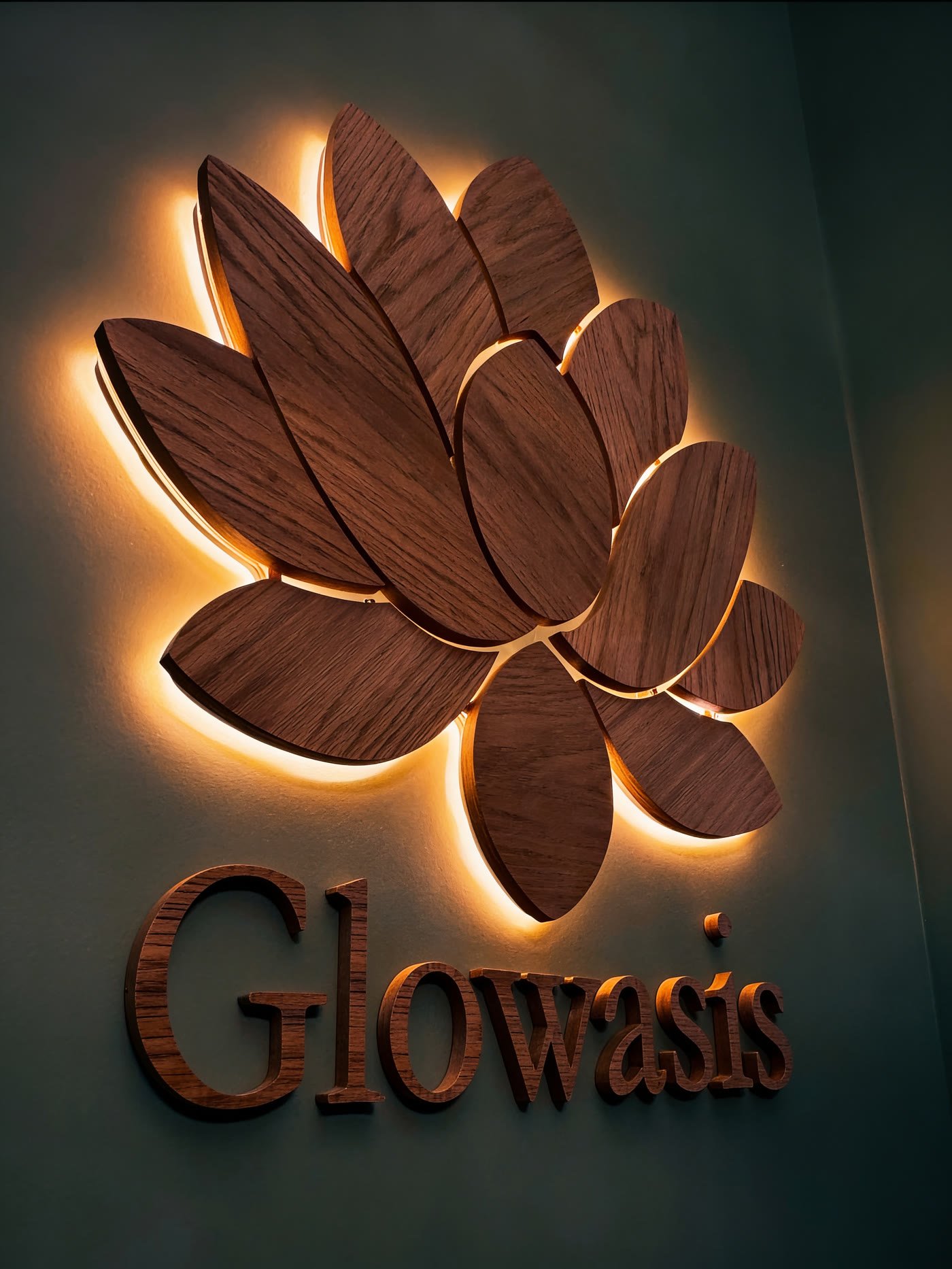 Wood lotus logo with halo lighting on an interior wall